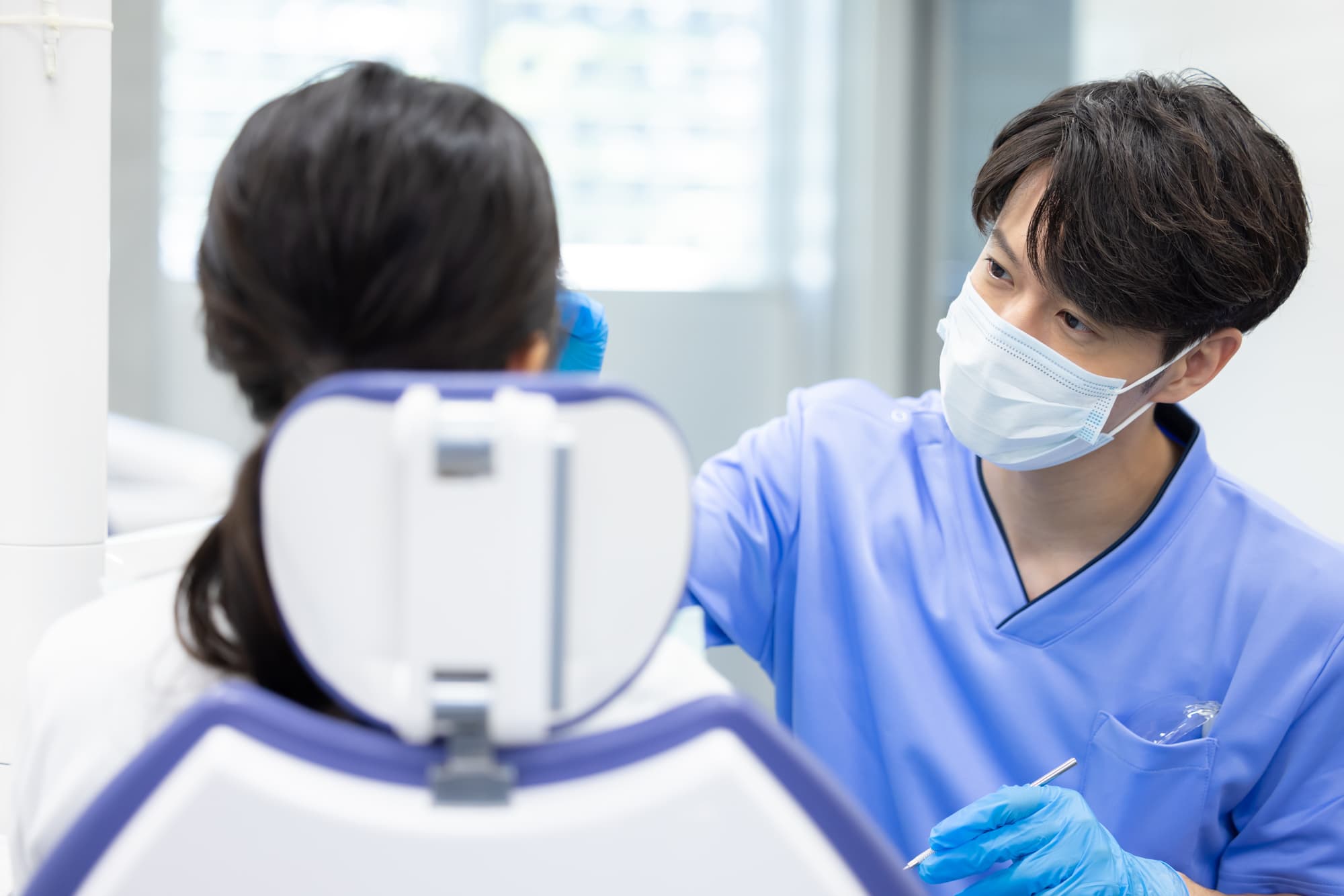 セラミックの歯が欠けて歯科医の診察を受ける患者