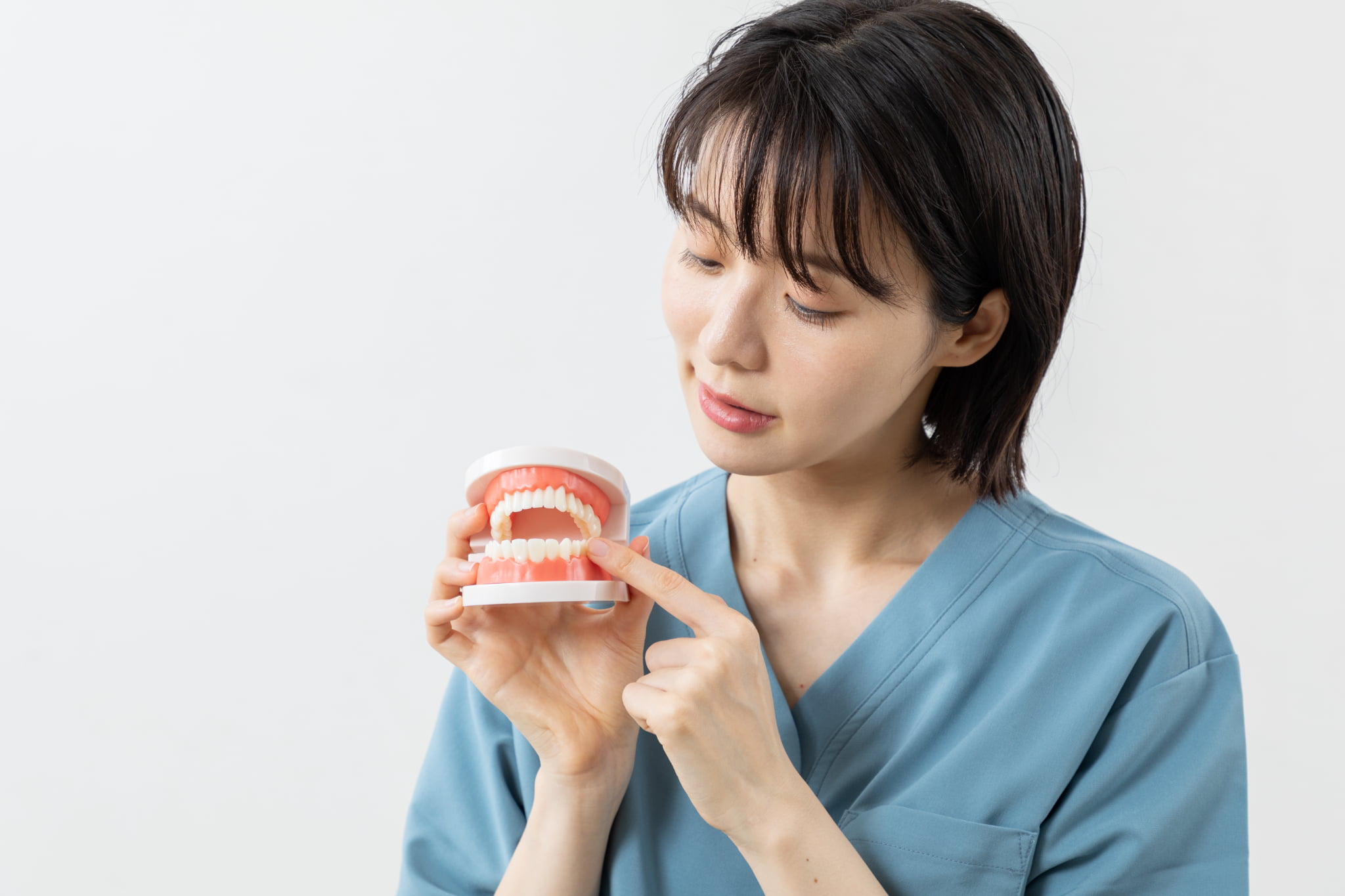 後戻りについて説明する歯科医師の女性