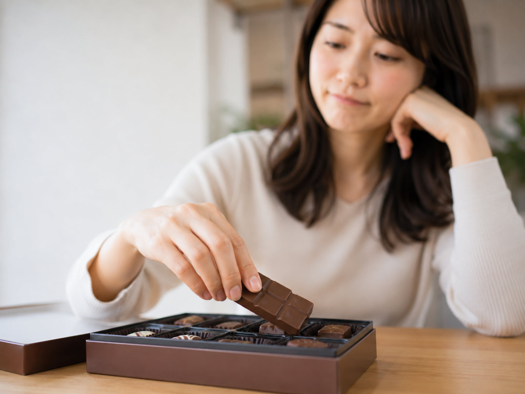 間食が多くチョコレートに手を伸ばす女性